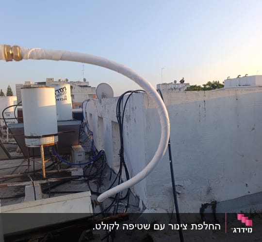 דוד שמש על גג עם צינורות וחיבורים